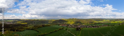Panoramic view of the green fields against the background of the cloudy blue sky.