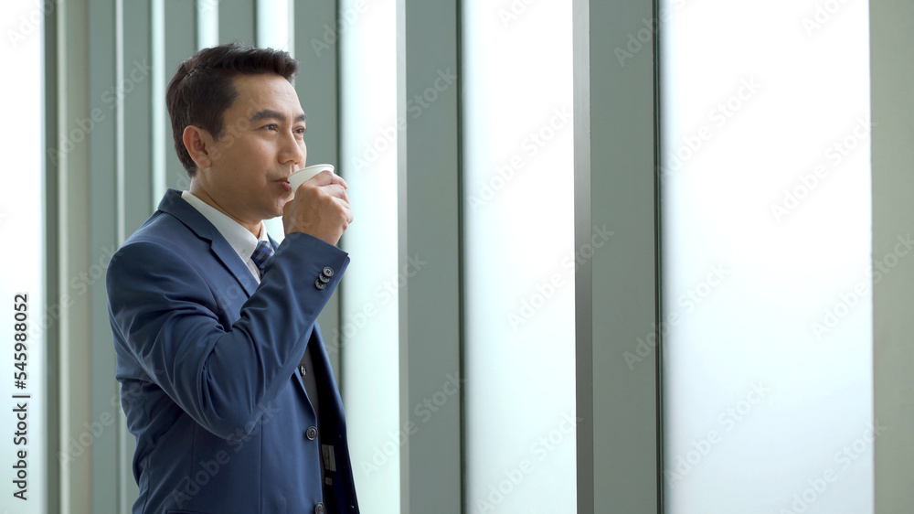 Smart and good looking Asian businessman relaxing and drinking a coffee. Smart and good looking Asian businessman relaxing and drinking a coffee.