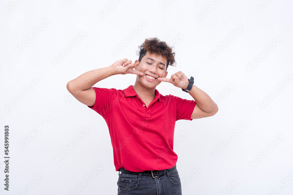 A lively man eagerly points to his teeth. Showing a nice, friendly smile. Isolated on a white background. A lively man eagerly points to his teeth. Showing a nice, friendly smile. Isolated on a white background.