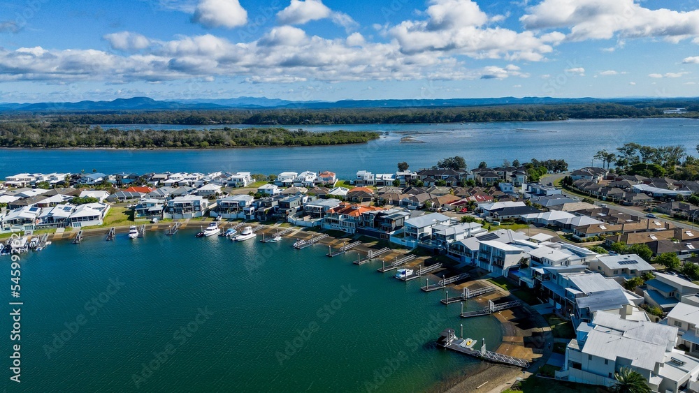 Aerial view of riverside Port Macquarie town in Australia and Hastings River under blue cloudy sky