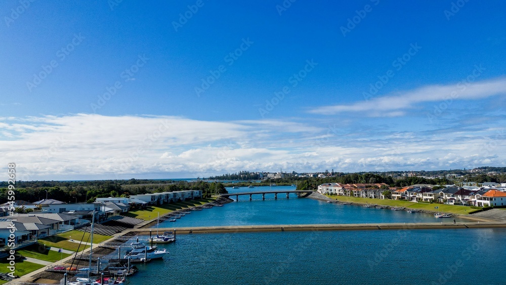 Aerial view of Hastings River and riverside Port Macquarie town in Australia under blue cloudy sky
