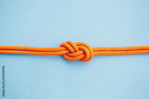 Eight knot on a rope on a blue background. Copy space