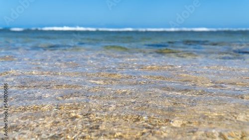 Closeup of sea waves washing the sandy beach on a sunny day