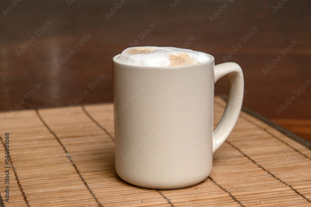 A cup of fresh coffee with cappuccino foam on the table A cup of fresh coffee with cappuccino foam on the table
