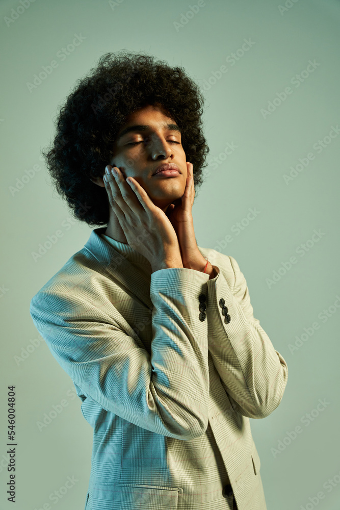 Young Hispanic man touching face Young Hispanic man touching face
