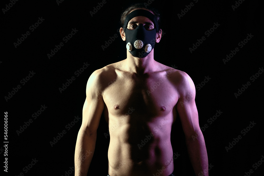 Fit young man training alone despite coronavirus pandemic using a training mask