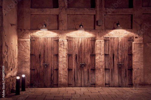 Amazing shot of ancient Arabic wooden doors illuminated by lamps at night