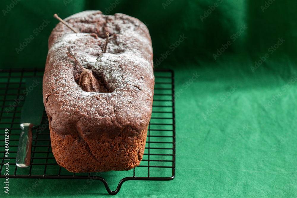 Chocolate pear cake on a green background. Rustic style.