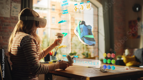 Female Shoes Designer Wearing Virtual Reality Headset and Using Controllers to Design a Fashionable Sneaker in Augmented Reality Software. Creative Woman Working on Custom Digital Footwear at Home. photo