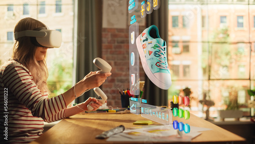 Female Shoes Designer Wearing Virtual Reality Headset and Using Controllers to Design a Fashionable Sneaker in Augmented Reality Software. Woman Working on Custom Digital Footwear at Home. photo