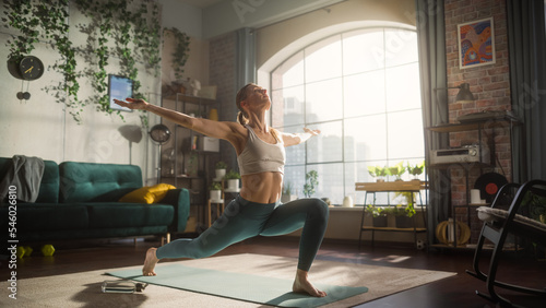 Young Athletic Woman Exercising, Stretching and Practising Yoga in the Morning in Her Bright, Sunny and Spacious Home Living Room. Healthy Lifestyle, Fitness, Wellbeing and Mindfulness Concept.
