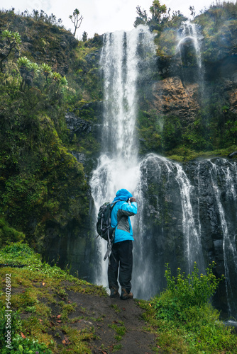 A hiker standing next to a Nithi waterfall at Chogoria Route, Mount Kenya National Park, Kenya