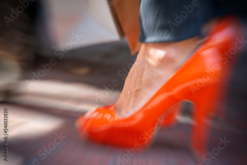 Fashion concept. Orange shoe with high heels and a cat on the background