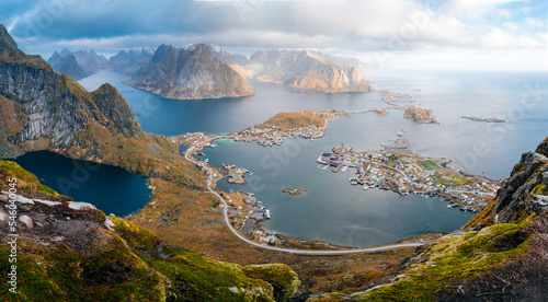 Panorama view during sunset or sunrise from the top of Reinebringen  Norway. View from mountain on fjords and Reine fishing village in Lofoten island. Steep mountains.