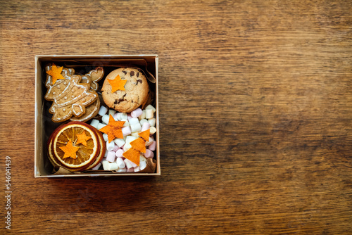Christmas Homemade Sweet Hampers. Christmas Sweet Gift Box. Festive treats Gift Hamper Idea for Adults and Kids. Box with Homemade different cookies and orange slices photo