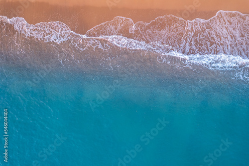 Turquoise water with wave with sand beach background from aerial top view. Concept summer sunny travel image