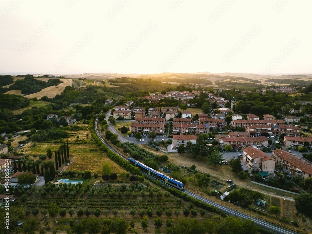 Aerial of a train going next to the town.