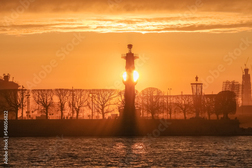 Russia, St. Petersburg, Rostral column on the banks of the Neva River in the rays of the setting sun