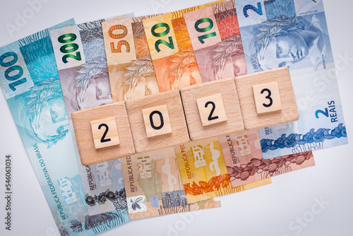 Brazilian money and the date 2023 on wooden blocks, Economic concept, Development of the Brazilian economy in 2023