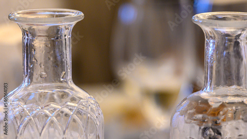 Two bottles of water - one sparkling the other flat. A glass of white wine in the distance between them.