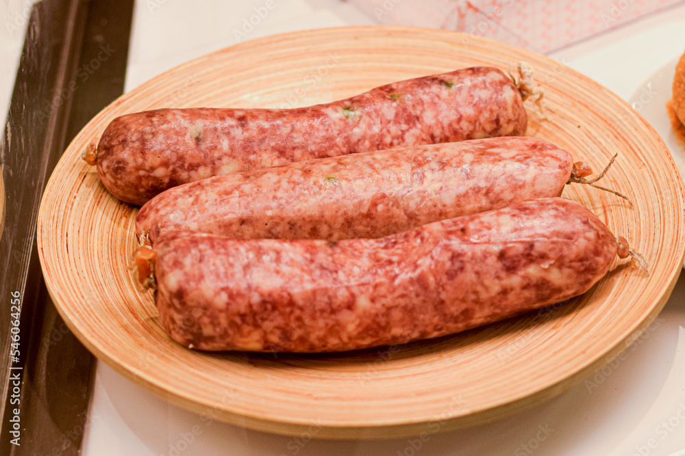 traditional meat sausages being served raw on the wooden plate traditional meat sausages being served raw on the wooden plate