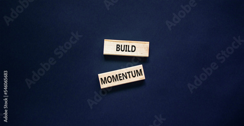 Build momentum symbol. Concept words Build momentum on wooden blocks. Beautiful black table black background. Business and build momentum concept. Copy space.
