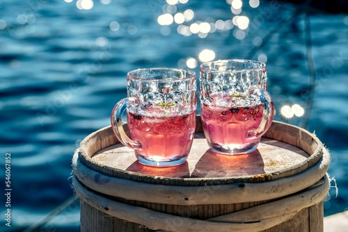 Obraz na plátně Beautiful shot of two pink lemonades with ocean water in the background