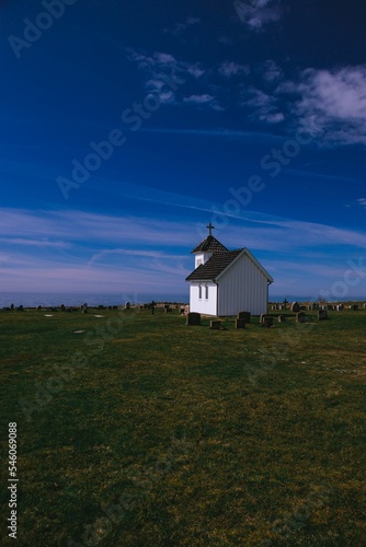 Vertical shot of an old village church and graveyard on a sunny day in Varhaug