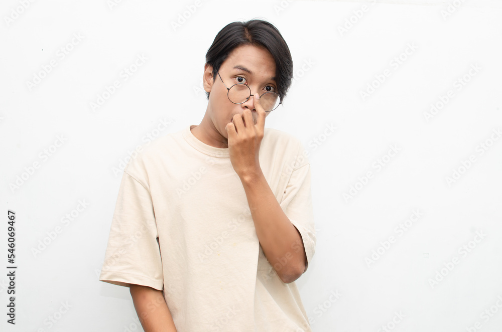 Asian young man wearing casual beige tshirt surprised, amazed, wow shocked raising arms gesturing victory and yes gesture Asian young man wearing casual beige tshirt surprised, amazed, wow shocked raising arms gesturing victory and yes gesture