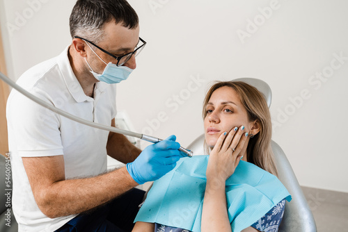 Attractive woman afraid of dentist. Dentist consults frightened girl in dentistry. Treatment of teeth and toothache in dentistry.