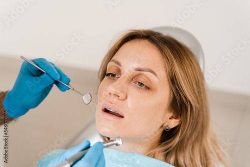 Consultation with dentist at dentistry. Teeth treatment. Dentist examines girl mouth and teeth and treats toothaches. Happy woman patient of dentistry.
