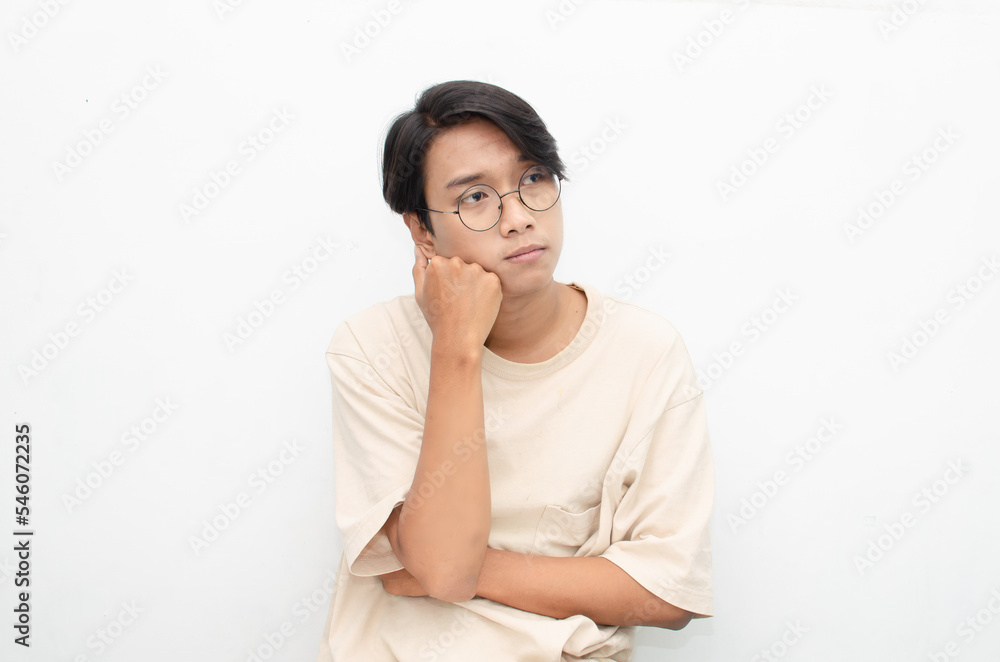 Thoughtful confused asian man thinking and wondering to choose something isolated over white background. man feeling uncertain and unsure. Thoughtful confused asian man thinking and wondering to choose something isolated over white background. man feeling uncertain and unsure.