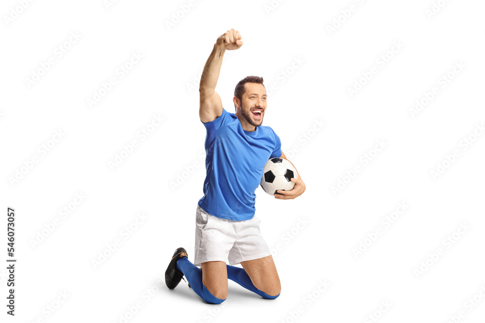 Excited fotball player holding a ball and kneeling