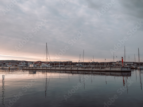 Pier in Sopot at sunrise time with amazing colorful sky. Many yachts and boats are moored at the pier. Poland. Europe. Vacation at sea. Selective focus.