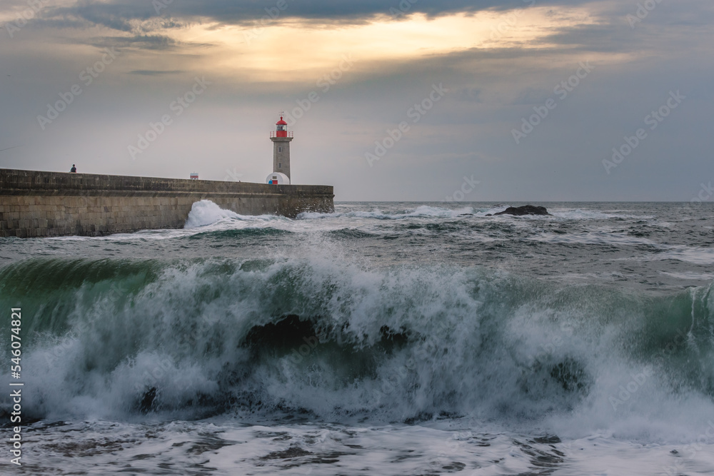 Storm waves over the lighthouse in a cloudy evening, Oporto, Portugal