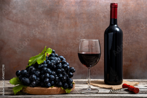 Red wine and grapes on wooden background