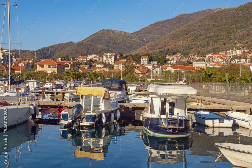 Beautiful Mediterranean landscape on sunny winter day. Fishing boats in harbor. Montenegro, view of Tivat city