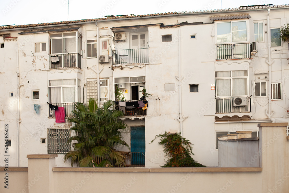 Old facade of white building in Spain. Spanish building property. Renting rooms and flats. 