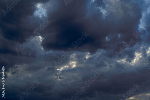 Summer evening sky in the picturesque clouds, lit by the rays of the setting sun.