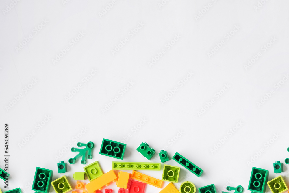 Colorful plastic building blocks flat lay on white background. Child developing game. Developing children games mockup. Colorful plastic bricks.copy space Colorful plastic building blocks flat lay on white background. Child developing game. Developing children games mockup. Colorful plastic bricks.copy space