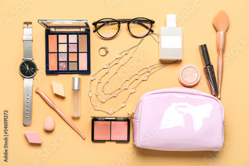Bag with cosmetics and accessories on beige background