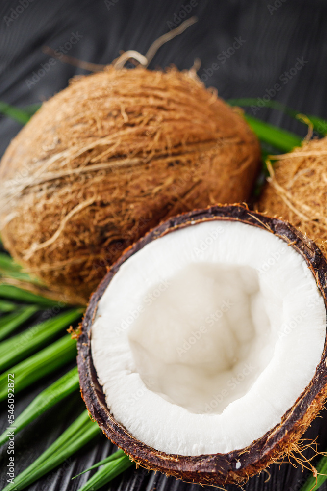 fresh natural coconut and shavings dried flakes on black wooden background fresh natural coconut and shavings dried flakes on black wooden background