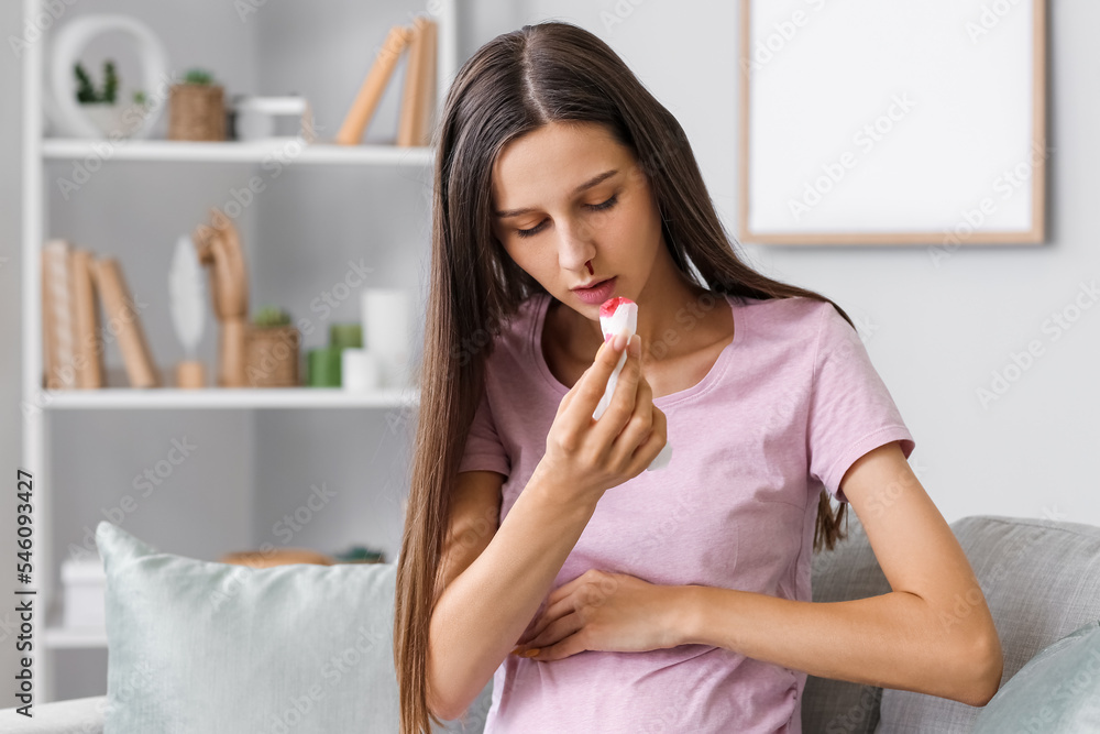 Young pregnant woman with nosebleed and tissue at home Young pregnant woman with nosebleed and tissue at home