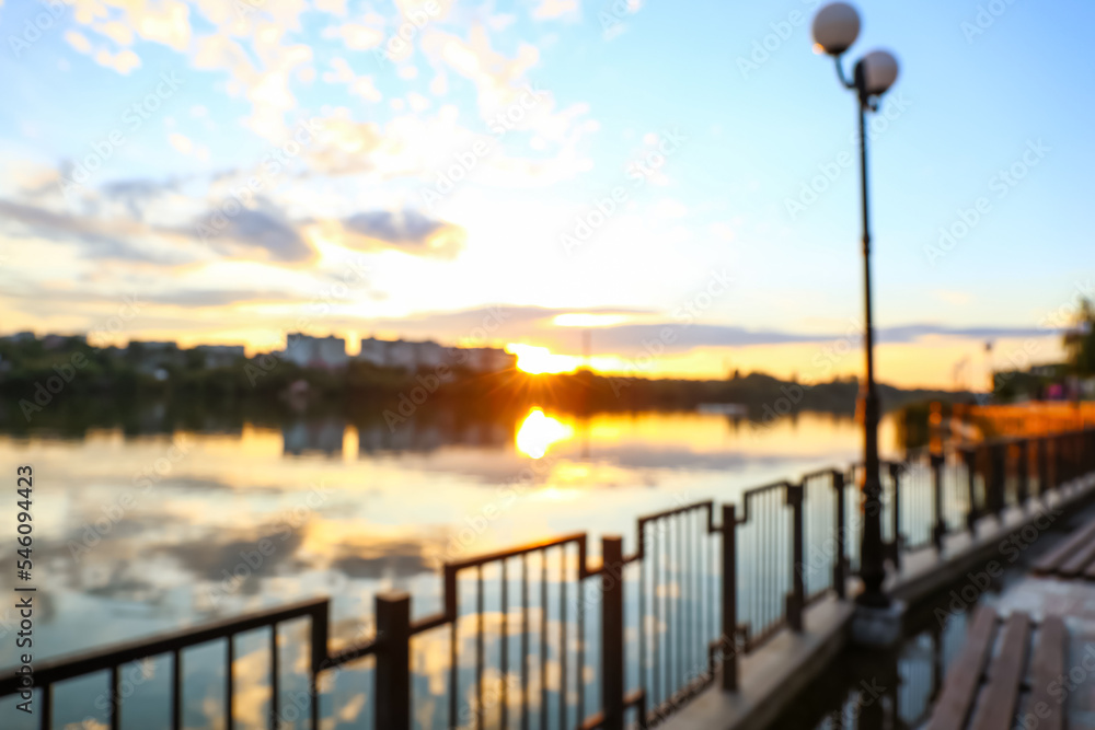 View of beautiful embankment with street lamp and fence at sunrise