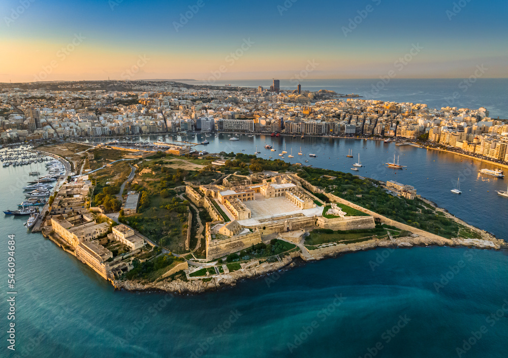 Aerial sunset view of Manoel island and fort, Sliema city on background. Gzira city, Malta