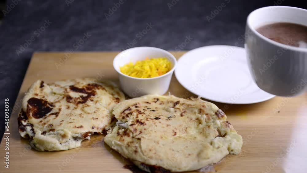 Video of a hand taking a cup of hot chocolate served with 2 pupusas and curtido. National Salvadoran national dish. Video of a hand taking a cup of hot chocolate served with 2 pupusas and curtido. National Salvadoran national dish.