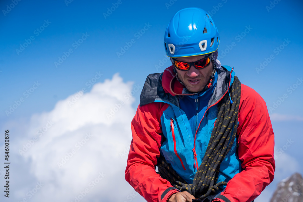 Man with sun glasses is climbing in the mountains.