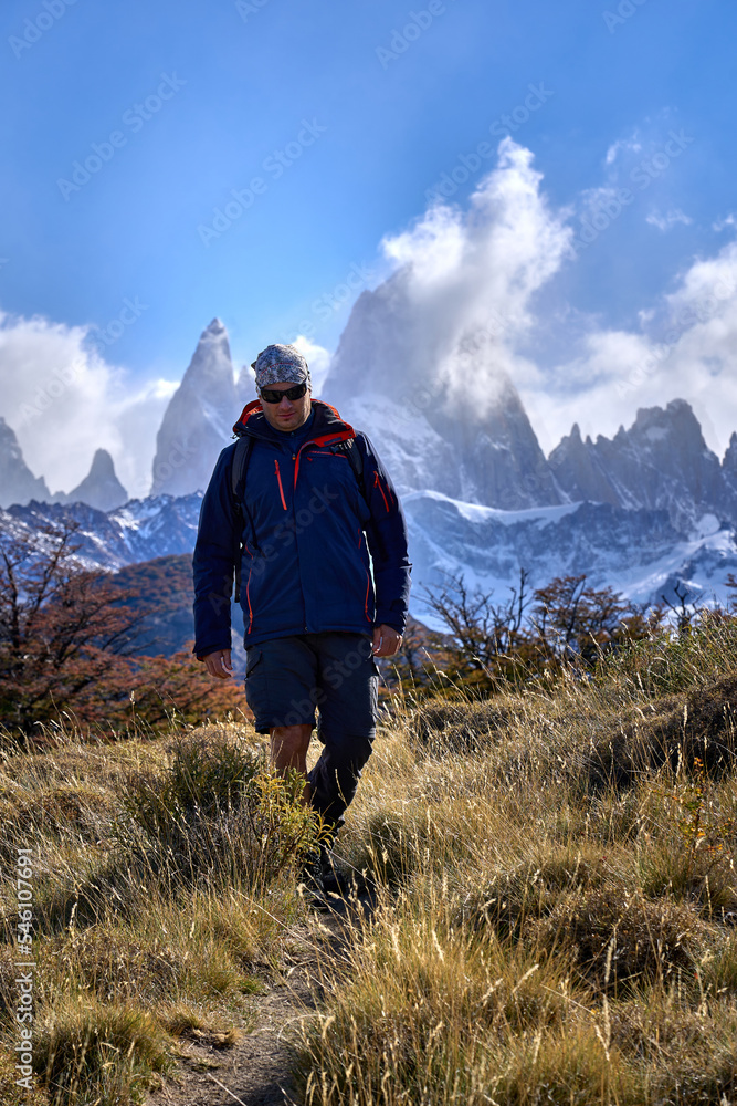 white man trekking in El Chalten, Patagonia Argentina. in the background you can see the Fitz Roy hill surrounded by clouds