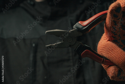 Bilde på lerret man's hand holding a black and red wire cutter plier open ready to cut form