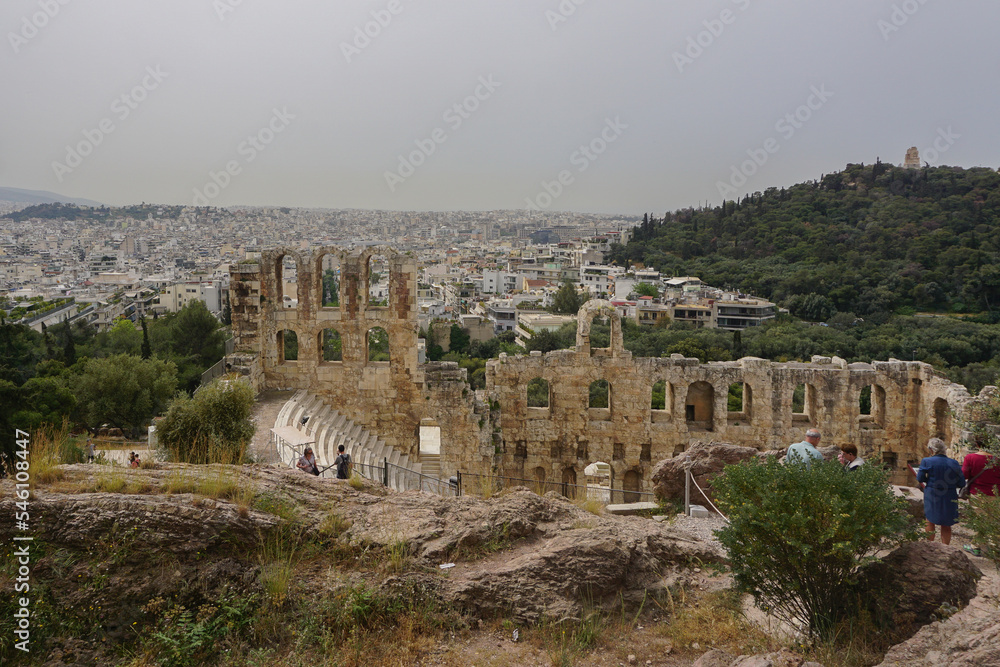 Athens, Greece: Tourists view the Odeum of Herodes Atticus at the Acropolis of Athens, under a hazy sky caused by dust pollution.